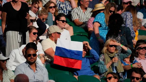 A spectator holding a Russian flag watches the men's singles third round match between Russia's Daniil Medvedev and Croatia's Marin Cilic last year. — AP